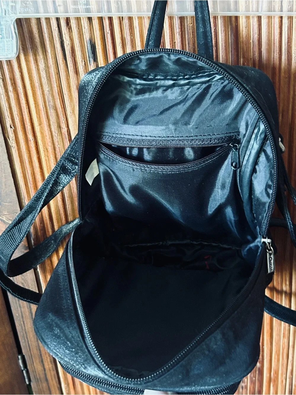Backpack mini style. Black little purse with lots of compartments and zippers.